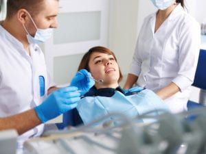 Woman being cared for by dentists