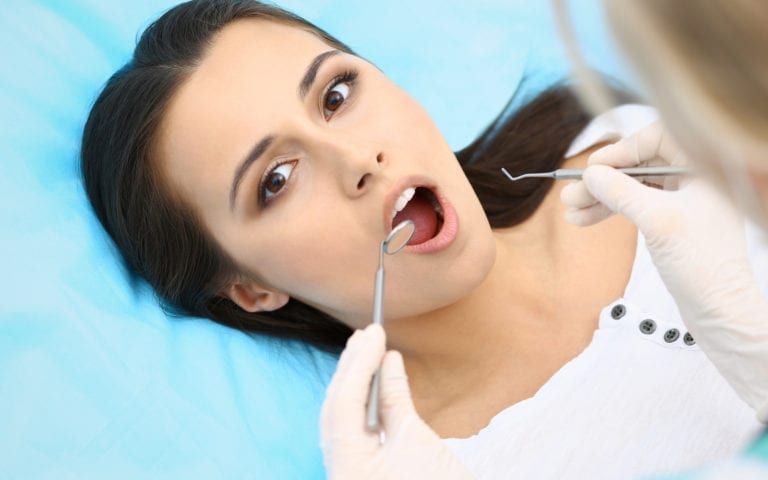 Woman receiving care by Dentist