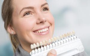 Dentist selecting a shade for a woman