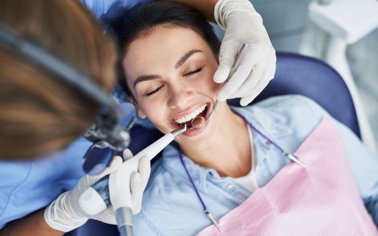 Woman recieving dental cleanings from dentist