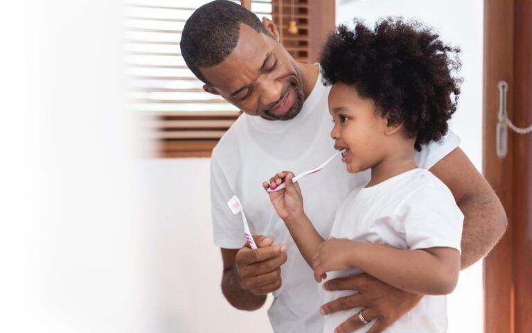 Father Caring For Daughter's Oral Health
