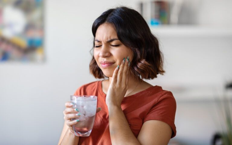 Woman with sensitive teeth after drinking cold water