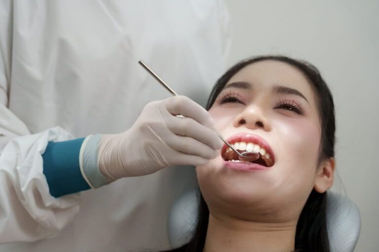 Dental mirror and scaler used to inspect teeth for plaque and tartar buildup before cleaning procedure.